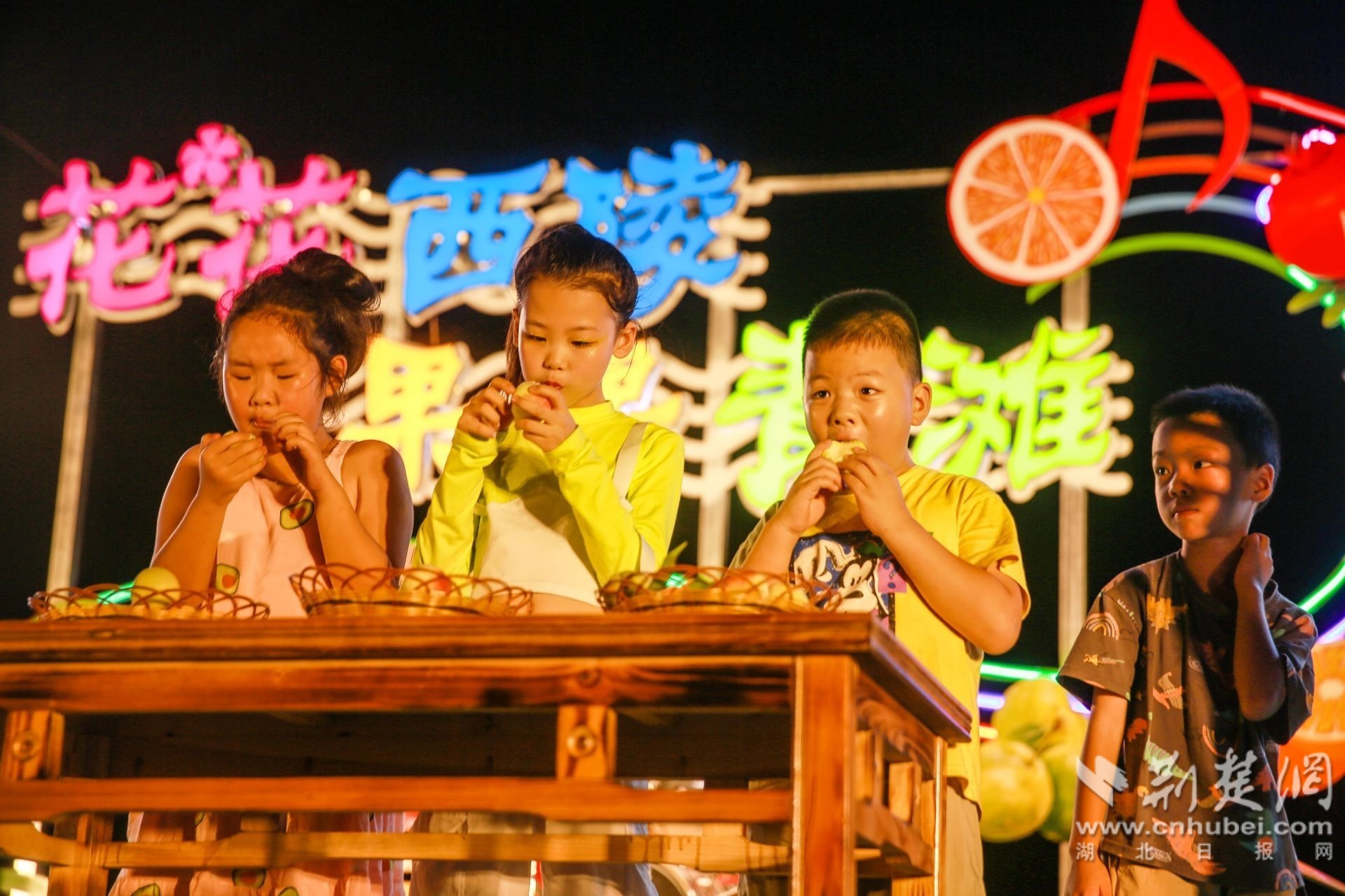 7月15日，游客在秭归县屈原镇西陵峡村江边“花花西陵&nbsp;果果青滩”小水果之夜音乐会上参加吃白花桃比赛。王罡 摄（02）.jpg.j
