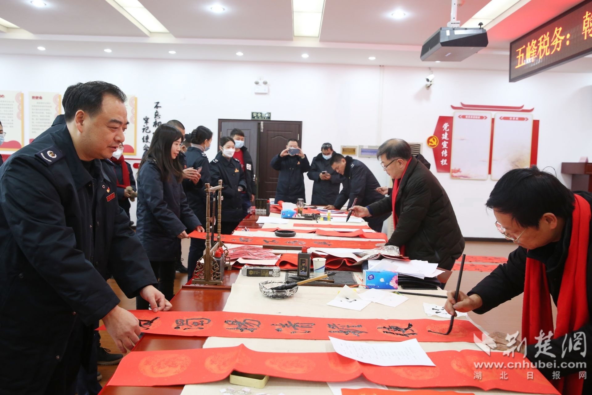 五峰土家族自治县税务局组织举办的“翰墨飘香迎新春 清峰税韵添廉味”活动现场，一幅幅蕴含廉洁教育意蕴的春联一气呵成、跃然纸上，五峰