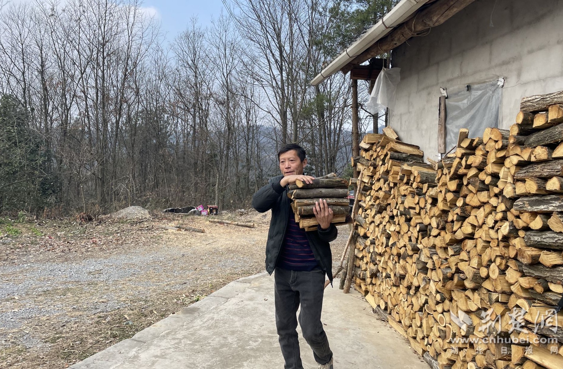 肖勇正在为杨生秀家添置木柴.jpg.jpg