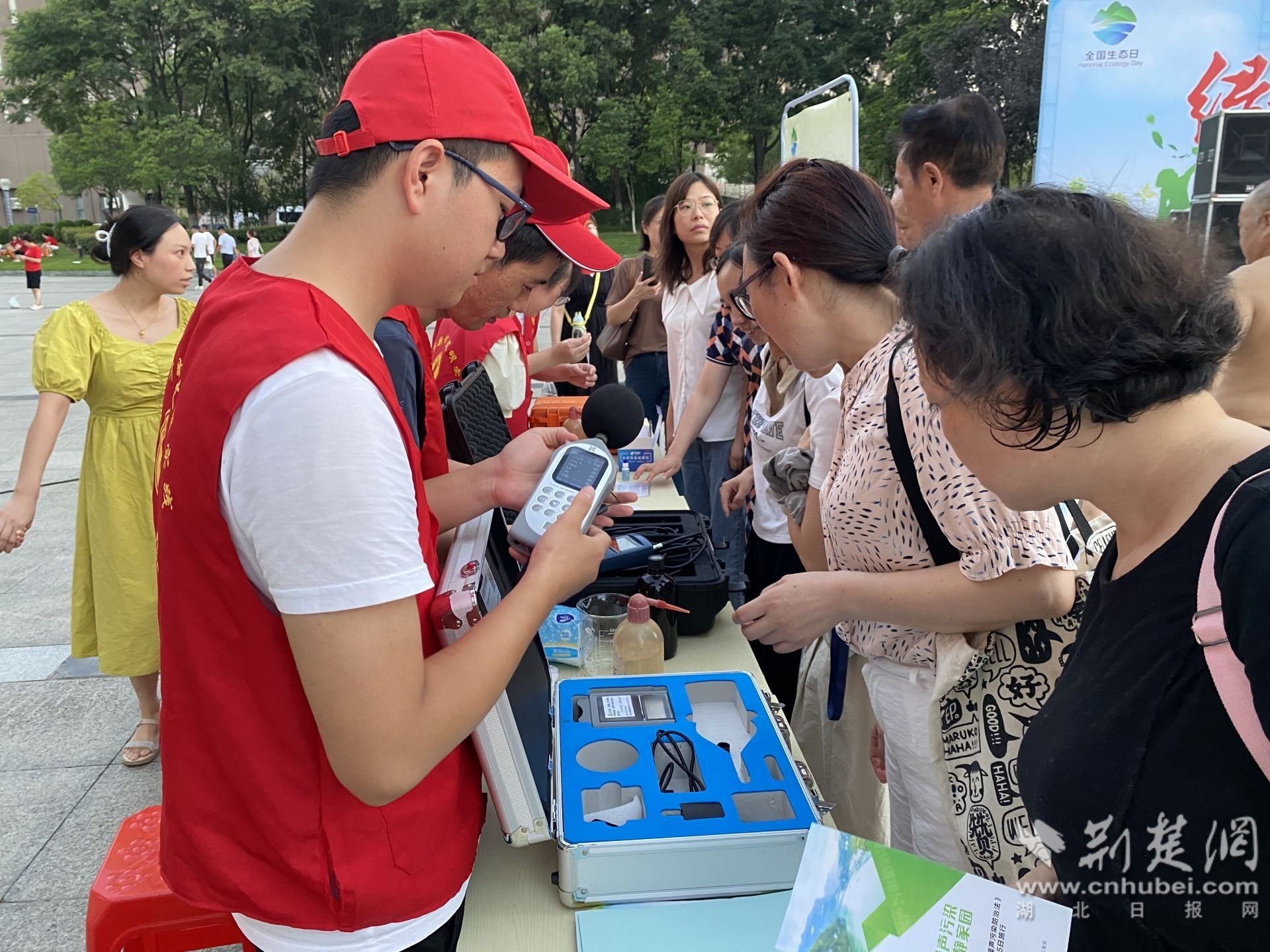 8月14日，湖北省当阳市举办首个”全国生态日“活动，吸引200余名市民参与。图为活动现场，志愿者向市民讲解生态环境执法设备。卢玉