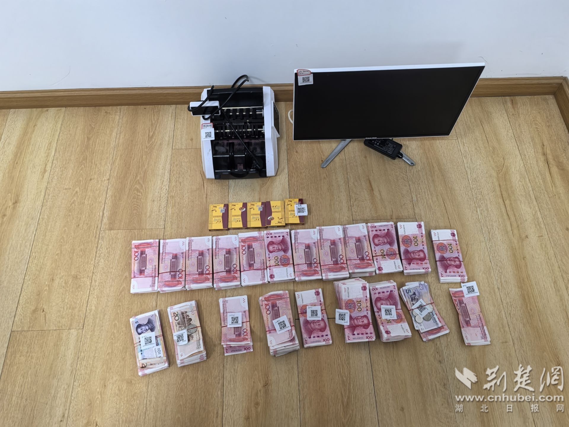 图说:赌场内被查获的近17万元赌资和验钞机、扑克牌、显示器等作案工具.jpg.jpg