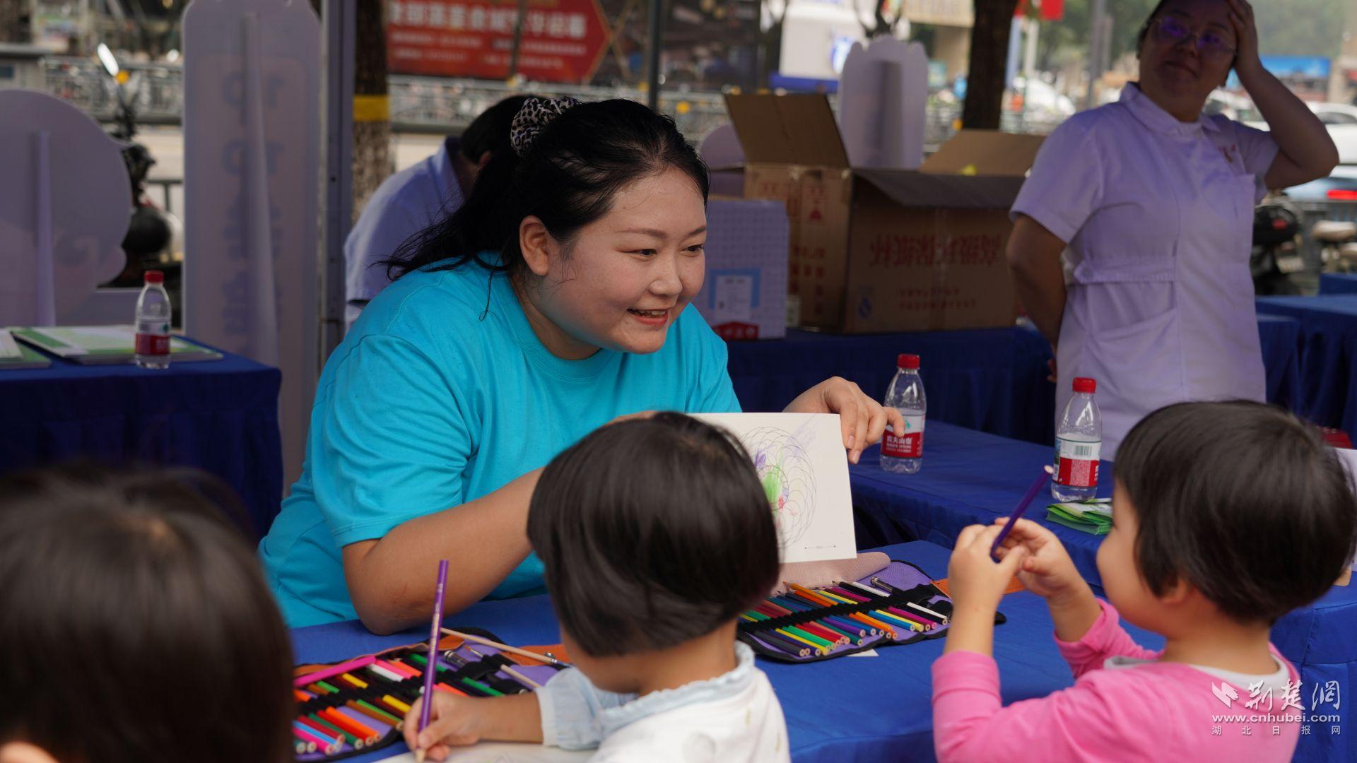 心理辅导互动区,优抚医院康复科医生现场引导小朋友体验绘画减压。石晓雯 摄.JPG.JPG