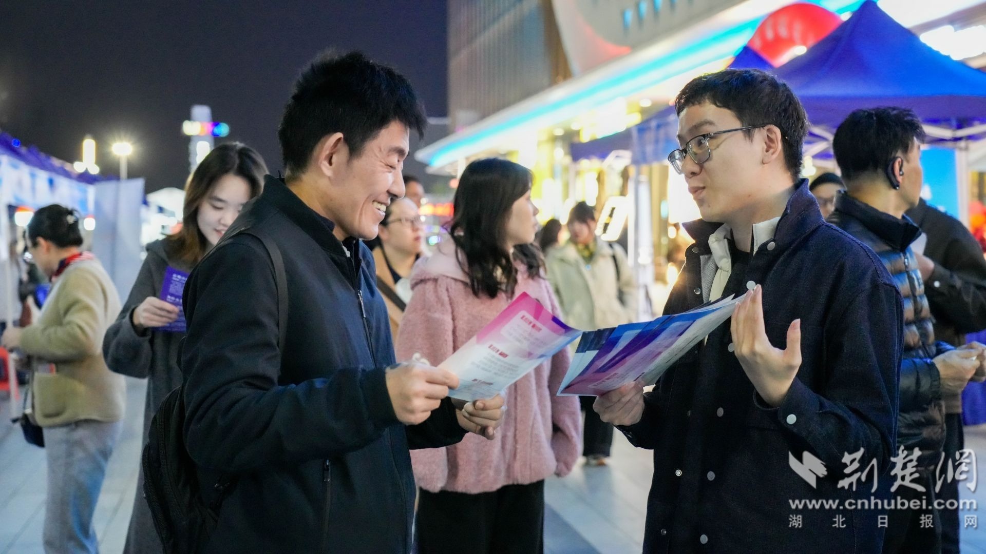 招聘负责人走出摊位，与求职者融洽交流。张文耀 摄.jpg.jpg