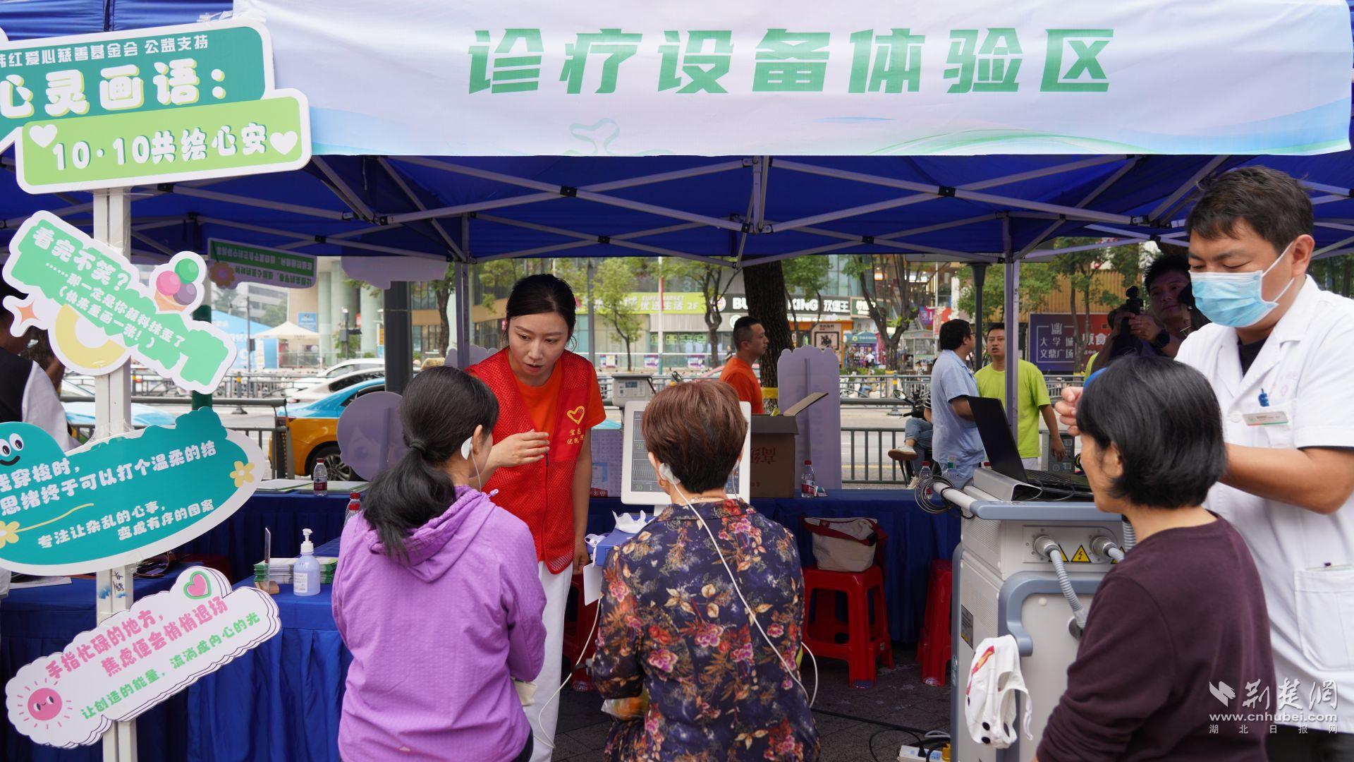 诊疗设备体验区的工作人员耐心演示物理治疗设备的原理和作用。石晓雯 摄.JPG.JPG
