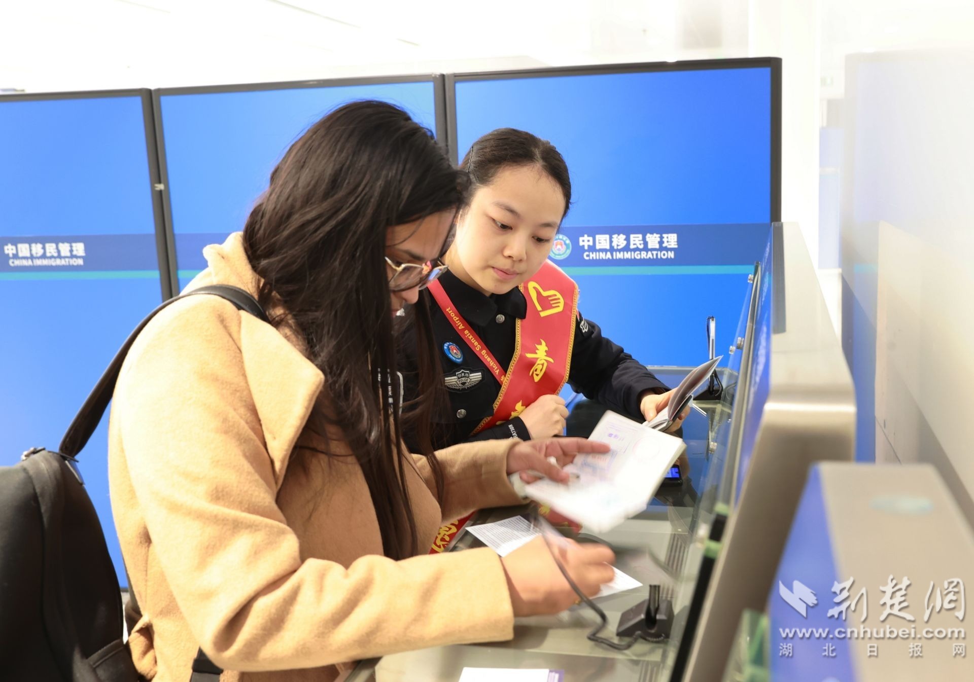 图为民警协助旅客办理手续 (钟鹏宇摄).JPG.JPG