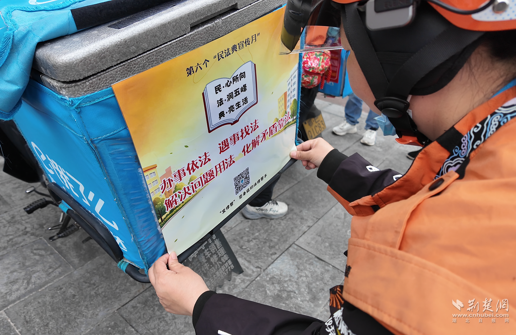“普法速递员”在外卖箱上张贴海报宣传民法典.png.png