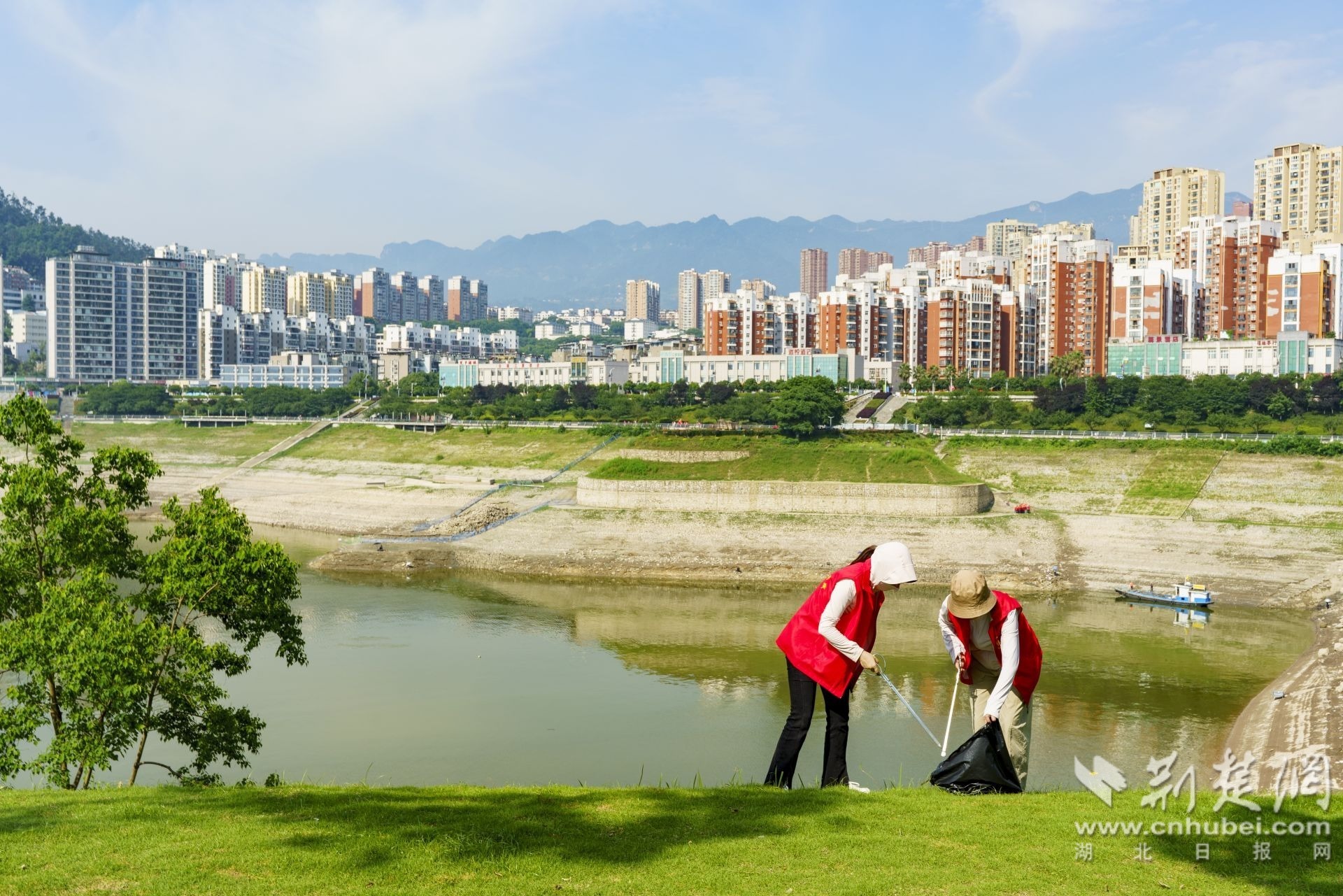 2026年6月4日，湖北省宜昌市秭归县，志愿者、碧绿江水、蓝天与城市构成一幅美丽生态画卷。 周仕伟 摄.JPG.JPG