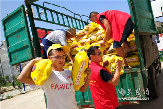 图为萤火虫学社队员陈塨同学(左1)和孝昌义工联合会队员一起为灾民分发大米_副本.jpg 图为萤火虫学社队员陈塨同学(左1)和孝昌义工联合会队员一起为灾民分发大米_副本.jpg