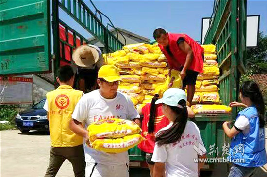 图为萤火虫学社队员胡召同学(左3)和孝昌义工联合会队员一起为灾民分发大米_副本.jpg 图为萤火虫学社队员胡召同学(左3)和孝昌义工联合会队员一起为灾民分发大米_副本.jpg